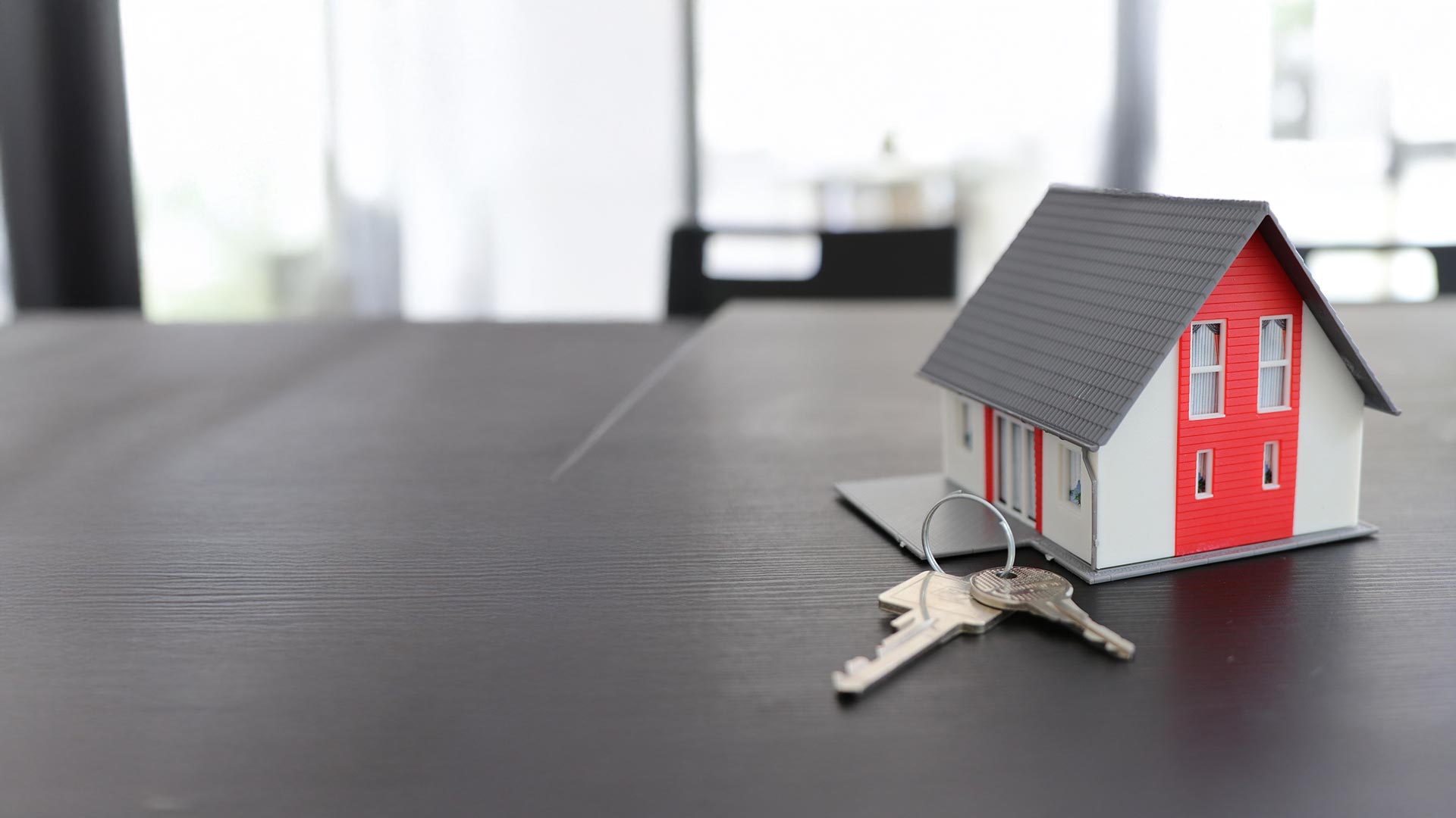 Casa in miniatura con chiavi – informazioni per i proprietari di immobili sul collegamento alla rete FTTH di Ascona4net ad Ascona